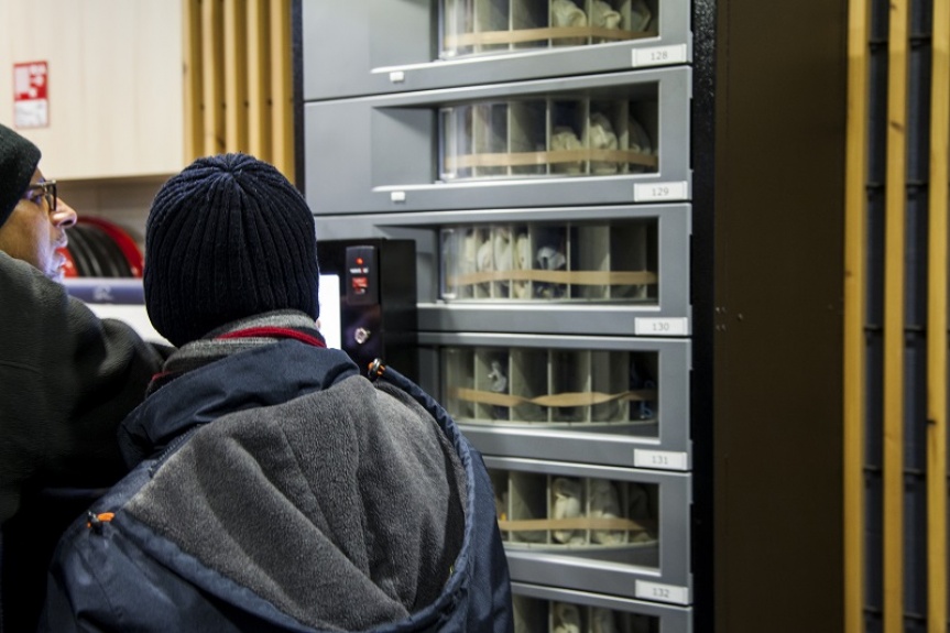 Photograph of two people in front of an automatic machine.