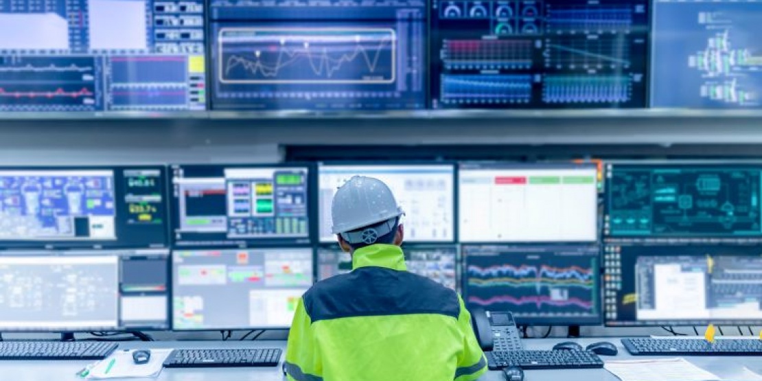 An employee analyses data and manages digital processes across multiple screens as part of a hyperautomation strategy