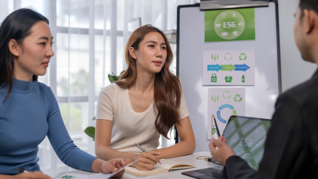 ) A team discussing ESG indicators to improve carbon accounting