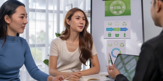 ) A team discussing ESG indicators to improve carbon accounting