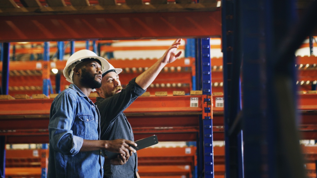 Des collaborateurs en entrepôt inspectant des rayonnages conformément à la norme NF EN 15635