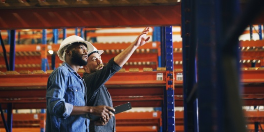 Des collaborateurs en entrepôt inspectant des rayonnages conformément à la norme NF EN 15635