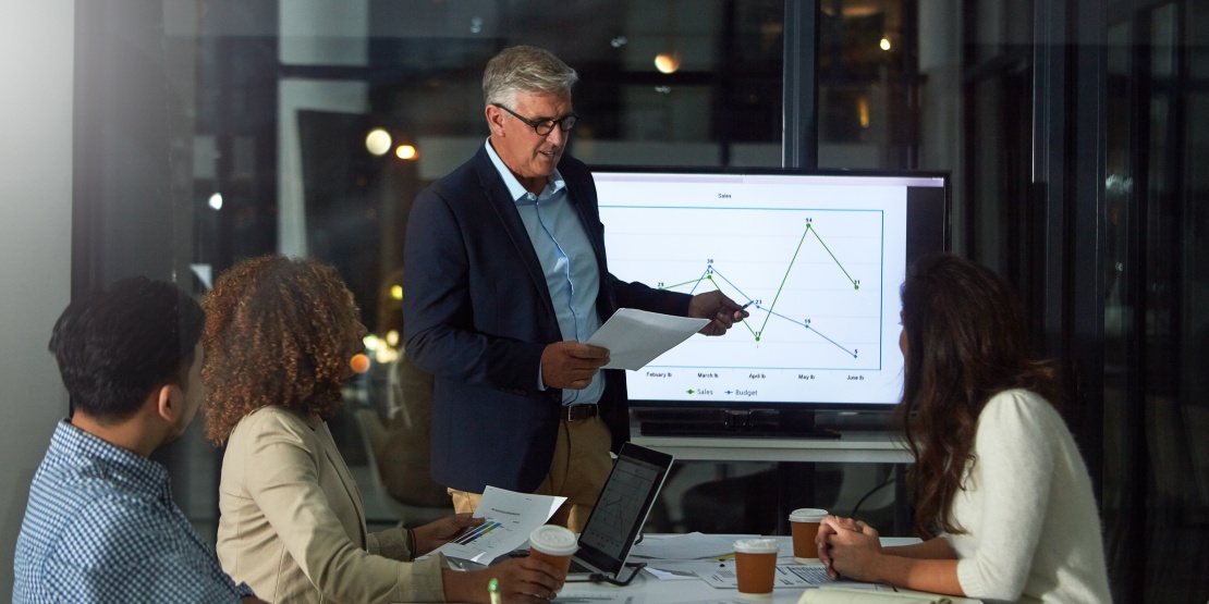 Two colleagues analysing dashboards to track and optimise the company's overhead costs.