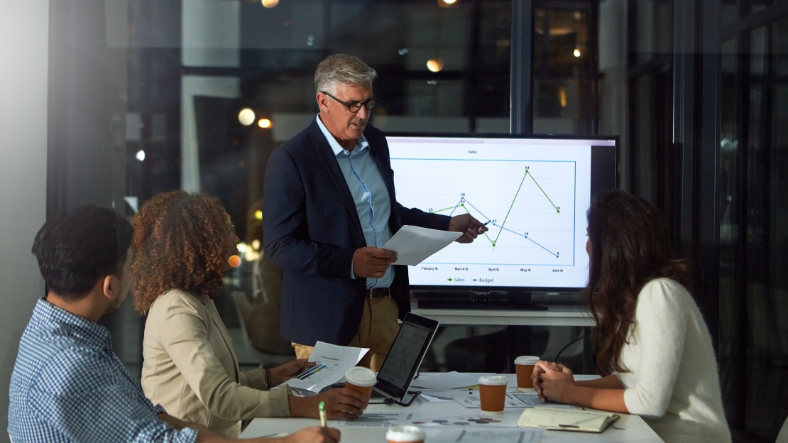 Two colleagues analysing dashboards to track and optimise the company's overhead costs.