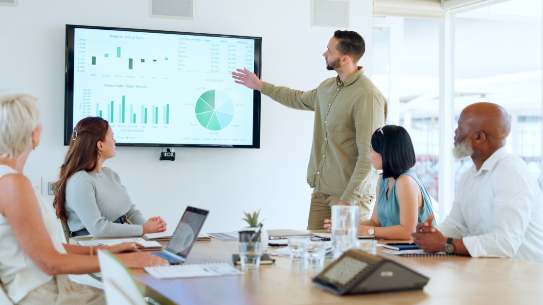 Une équipe échange autour d’indicateurs de performance afin d’évaluer les bénéfices de l’externalisation des achats et d’optimiser la stratégie d’approvisionnement.