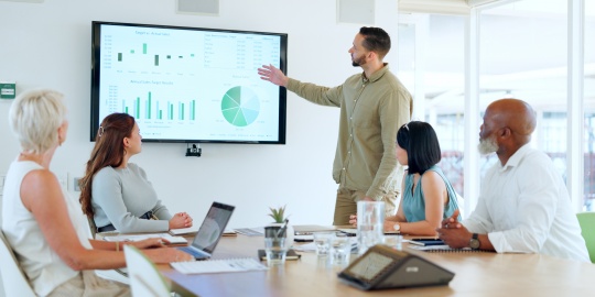 Une équipe échange autour d’indicateurs de performance afin d’évaluer les bénéfices de l’externalisation des achats et d’optimiser la stratégie d’approvisionnement.