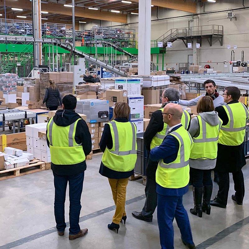 Groupe de personnes visitant un entrepôt de Manutan pour représenter les partenaires