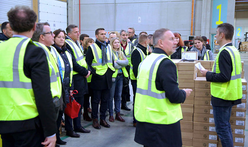 People gathered in front of a warehouse in Manutan receiving information