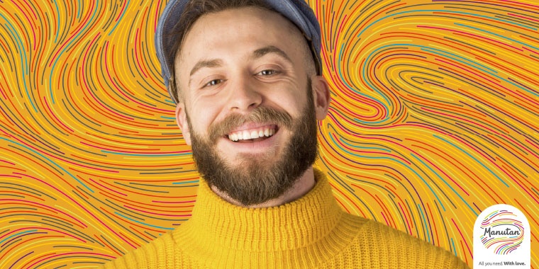 Photo of a man wearing a yellow jumper with a background of coloured waves 