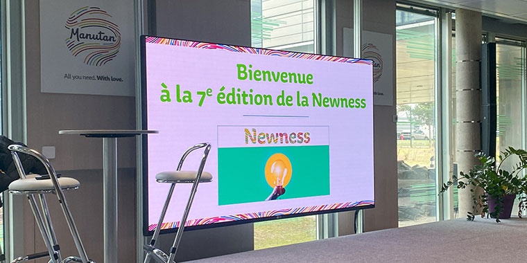 Photo of a large screen with the words Welcome to the 7th edition of Newness