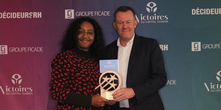 Photo of two Manutan employees carrying a trophy