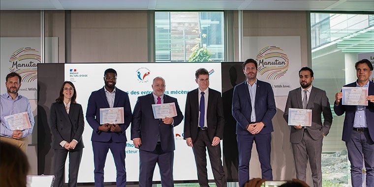 Photo taken at the launch of the territorial sponsorship fund: a group of participants pose on stage, holding a document, with the Manutan logo in the background.