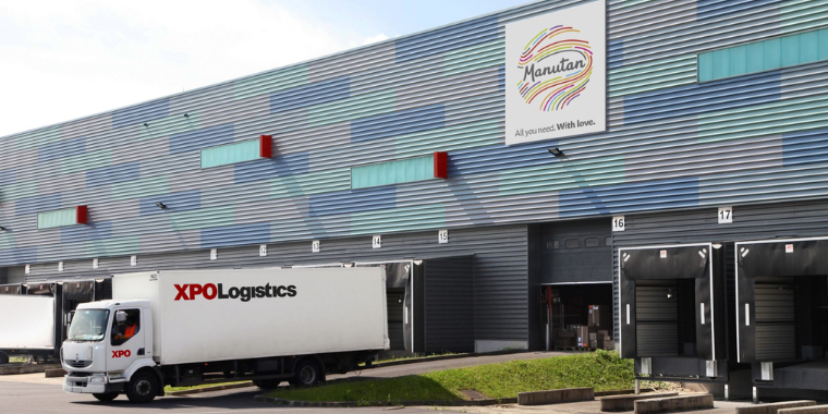 XPO lorry parked in front of a Manutan warehouse with the Manutan logo visible on the building.