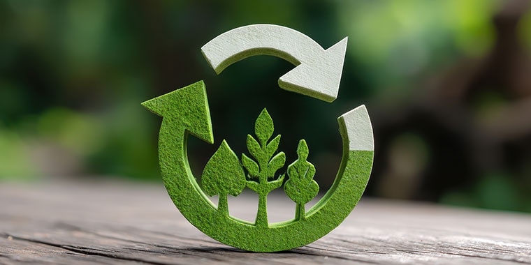 Symbole de recyclage vert avec des arbres, représentant la durabilité et l’économie circulaire.