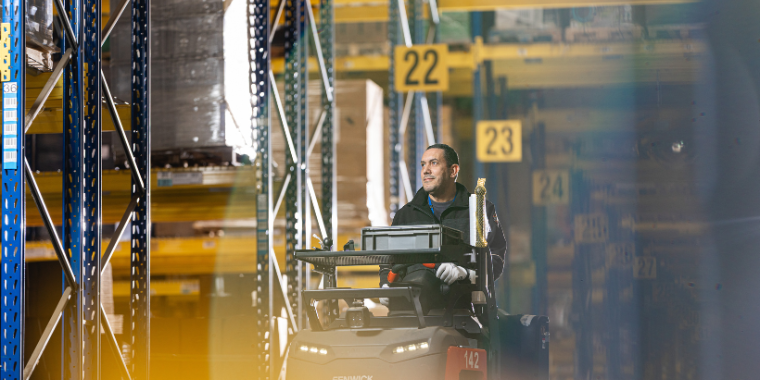 Manutan employee operating a pallet truck in a warehouse