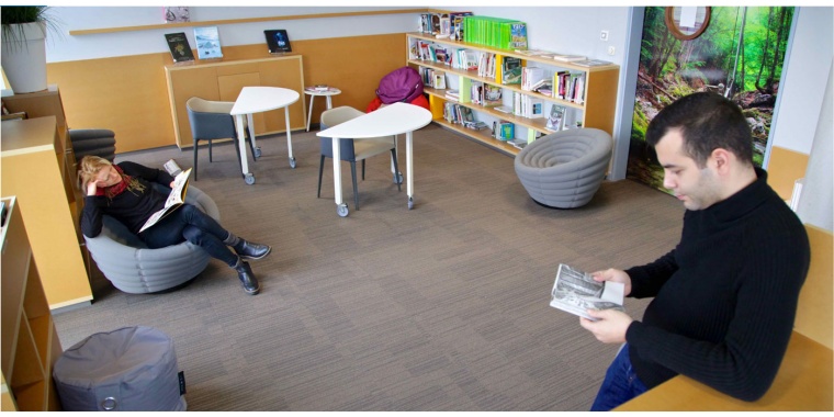 Collaborateurs lisant en salle de lecture pour représenter la qualité de vie au travail chez Manutan