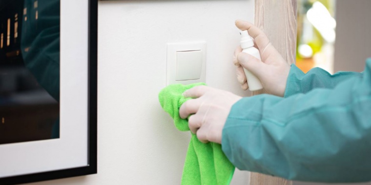 Employé désinfectant un interrupteur