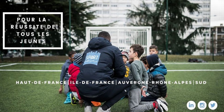 Photo showing children with a coach crouching on the ground of a stadium