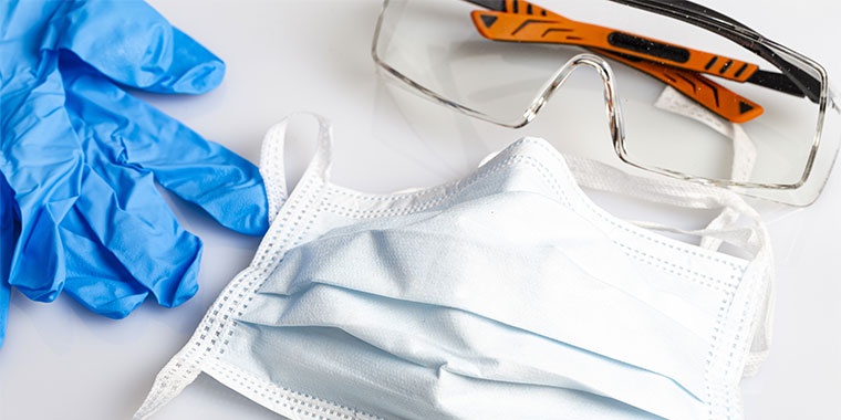 Photo représentant des gants, un masque et une paire de lunette de travail.