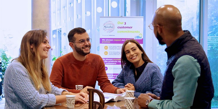 Photo représentant quatre collaborateurs Manutan autour d'une table. 